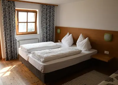 a large bed in a bedroom with a window at Residence Streitlhof in Tirolo