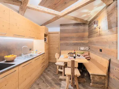 a kitchen with wooden walls and a wooden table at CESA MARIN in Campitello di Fassa
