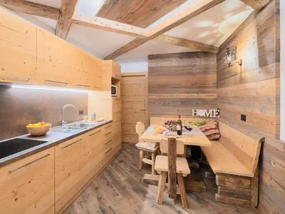 a kitchen with wooden walls and a table and a sink at CESA MARIN in Campitello di Fassa