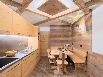 a kitchen with wooden walls and a wooden table at CESA MARIN in Campitello di Fassa