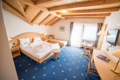 a living room with a table and a window at Hotel Pra Tlusel in Selva di Val Gardena