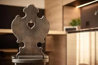 a wooden chair with a heart carved into it at Appartement- und Wellnesshotel Winkler in Falzes