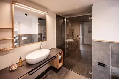 a bathroom with a sink and a shower at Appartement- und Wellnesshotel Winkler in Falzes