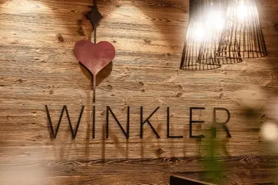 a wooden wall with a heart and the word wildlife at Appartement- und Wellnesshotel Winkler in Falzes