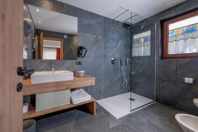 a bathroom with a sink and a shower at Dolomiten Hotel Irma in Canazei