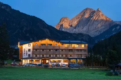 a building with a sign on the side of it at Dolomiten Hotel Irma in Canazei