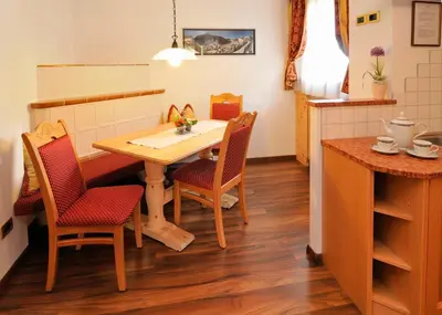 a kitchen and dining room with a table and chairs at Garni Hotel Iris in Selva di Val Gardena