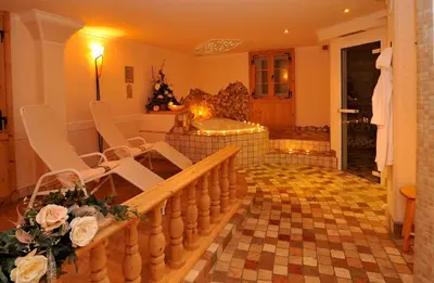 a living room with a staircase and a christmas tree at Garni Hotel Iris in Selva di Val Gardena
