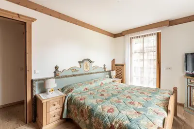 a bedroom with a bed and a tv and a window at Aurturist Appartement 185 in San Vigilio Di Marebbe