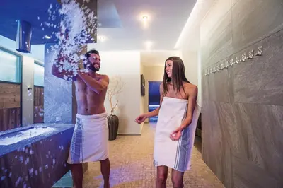 a man and a woman standing in a bathroom at Hotel Kronblick in Chienes