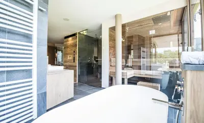 a bathroom with a tub and a sink and a mirror at Hotel Kronblick in Chienes