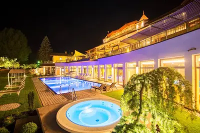 a large building with a swimming pool at night at Hotel Kronblick in Chienes