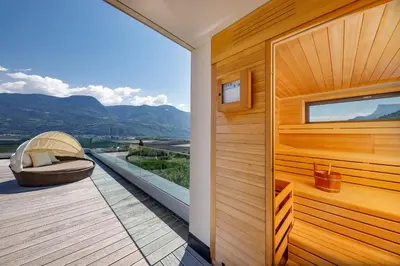 a balcony with a bench and a view of the mountains at Hotel Törggelehof in Cermes