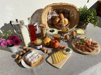 a table with food and bread and a basket of food at Rasiglerhof in Villandro