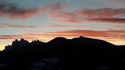 a silhouette of mountains with a sunset in the background at Rasiglerhof in Villandro