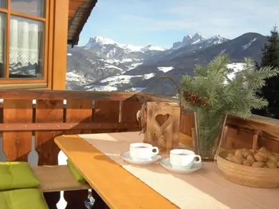 a table with two coffee cups on a balcony with mountains at Rasiglerhof in Villandro