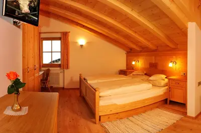 a bedroom with a large bed in a room at Agriturismo Maso Larciunei in Selva di Val Gardena
