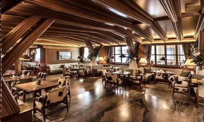 a restaurant with wooden ceilings and tables and chairs at Alpen Hotel Corona in Vigo di Fassa