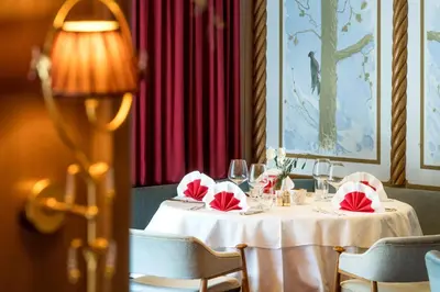 a table with a white table cloth and red napkins at Alpen Hotel Corona in Vigo di Fassa