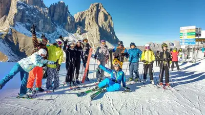 a group of people posing for a picture on a ski slope at Alpen Hotel Corona in Vigo di Fassa