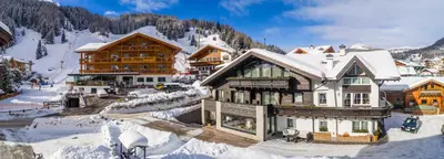 a ski lodge with snow on the ground at Chalet Elisabeth dolomites alpin & charme in Selva di Val Gardena