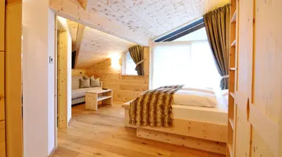 a bedroom with a bed and a window at Chalet Elisabeth dolomites alpin & charme in Selva di Val Gardena