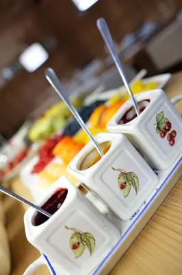 a tray of food on a table with cherries and sauce at Chalet Elisabeth dolomites alpin & charme in Selva di Val Gardena