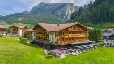 a woman sitting on a couch tying her shoe at Freina Mountain Lifestyle Hotel in Selva di Val Gardena