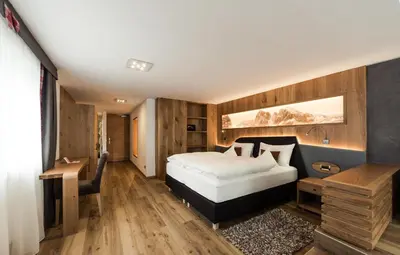 a bathroom with a jacuzzi tub next to a door at Freina Mountain Lifestyle Hotel in Selva di Val Gardena