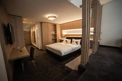 a bedroom with a white bed and wooden walls at Freina Mountain Lifestyle Hotel in Selva di Val Gardena