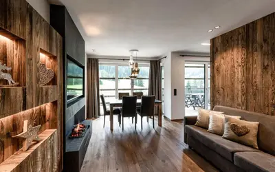 a living room with a couch and a table at Cadepunt The Dolomites Lodge in Selva di Val Gardena