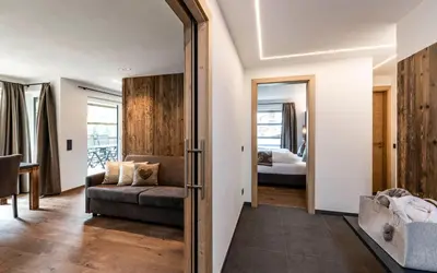 a living room with a couch and a mirror at Cadepunt The Dolomites Lodge in Selva di Val Gardena