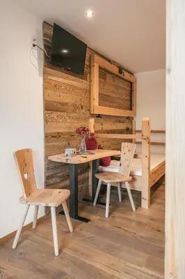 a room with a table and two chairs and a bed at Pension Wiesenhof in Campo di Trens