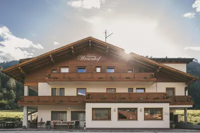 a large building with a balcony on top of it at Pension Wiesenhof in Campo di Trens