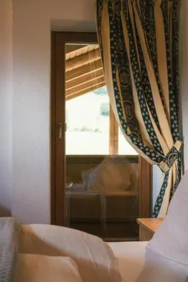 a bedroom with a window with a curtain at Pension Wiesenhof in Campo di Trens