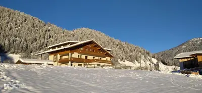 a ski lodge in the mountains in the snow at Pension Wiesenhof in Campo di Trens