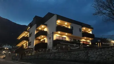 a large white building with lights on it at night at Hotel Zum Tiroler Adler in Tirolo
