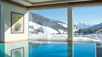 a swimming pool with a view of a snow covered mountain at Hotel Trenker in Braies