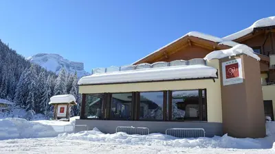 a building with snow on the ground in front of it at Hotel Trenker in Braies