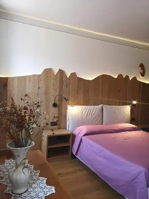 a bedroom with a bed with a ladder and a painting at Ampia casa in Cavalese in Cavalese