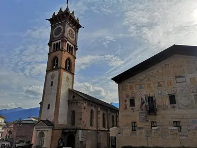 a building with a clock tower on top of it at Ampia casa in Cavalese in Cavalese