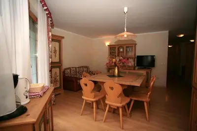 a kitchen with wooden cabinets and a wooden table at Casa Maurivan in Canazei
