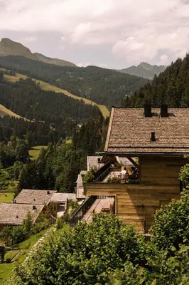 a group of buildings with mountains in the background at Mons Silva Private Luxury Chalets in Racines