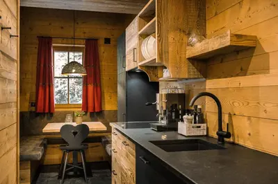a kitchen with wooden walls and a sink and a window at Mons Silva Private Luxury Chalets in Racines