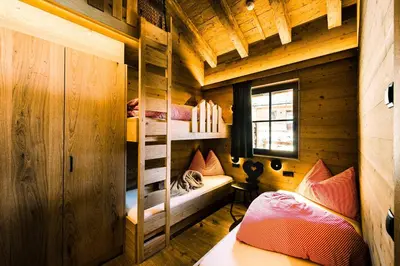 a room with bunk beds in a wooden cabin at Mons Silva Private Luxury Chalets in Racines