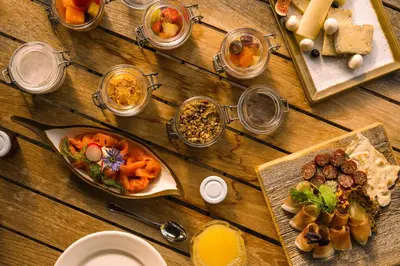 a wooden table with many plates of food on it at Mons Silva Private Luxury Chalets in Racines