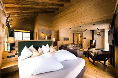 a bedroom with a bed and a living room at Mons Silva Private Luxury Chalets in Racines