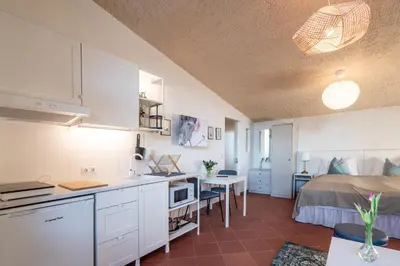 a kitchen and a bedroom with a bed and a table at Schloss-Castel Pienzenau - Guestrooms & Apartments - B&B-Hotel & Restaurant in Merano