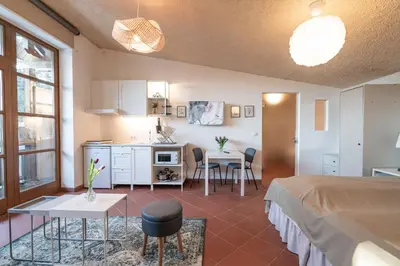 a room with a bed and a table and a kitchen at Schloss-Castel Pienzenau - Guestrooms & Apartments - B&B-Hotel & Restaurant in Merano