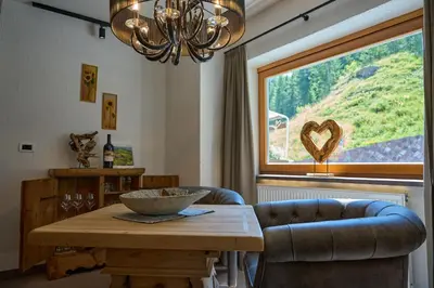 a dining room with a table and a large window at Hotel Monte44 in Selva di Val Gardena